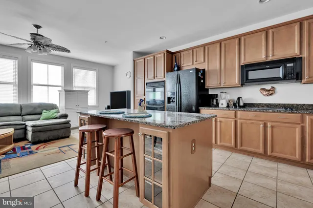 a kitchen with kitchen island granite countertop a stove top oven a sink dishwasher and a refrigerator