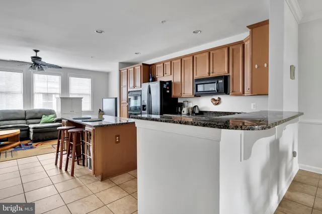 a kitchen with stainless steel appliances granite countertop a stove top oven a sink a refrigerator and a granite counter tops