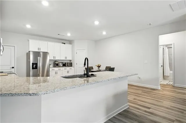 a kitchen with stainless steel appliances granite countertop a sink and a refrigerator