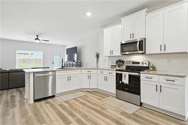 a kitchen with granite countertop white cabinets and white appliances