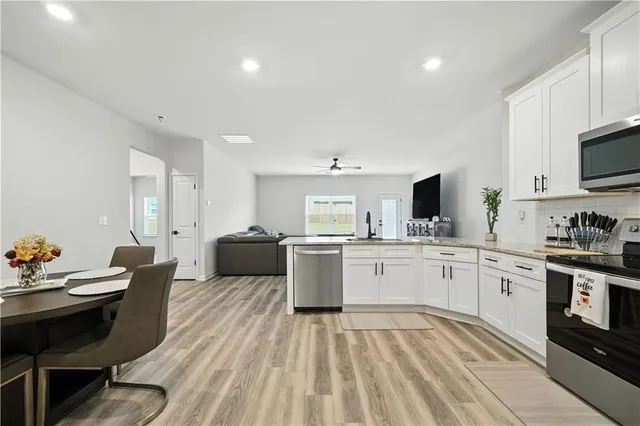 a kitchen with a sink white cabinets and appliances