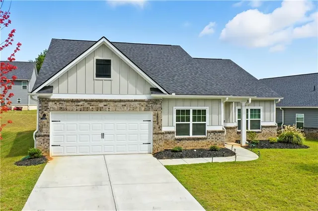 a front view of a house with a yard garage and outdoor seating