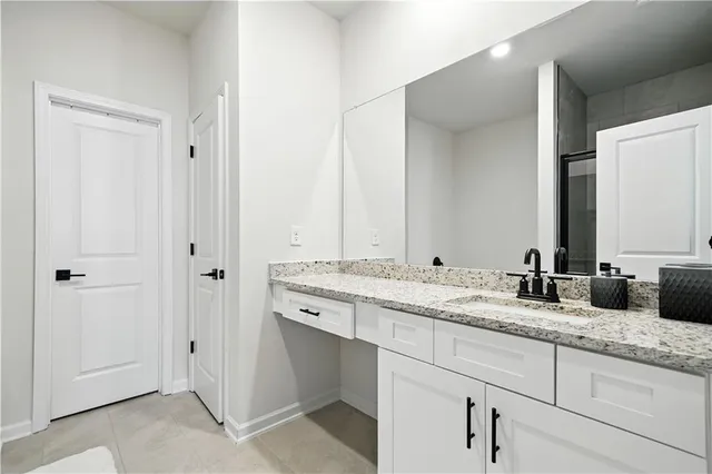 a bathroom with a granite countertop double vanity sink and a mirror