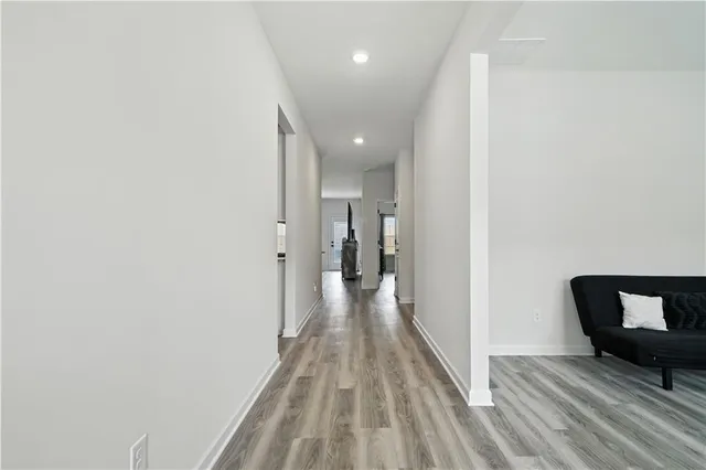 a view of a hallway with wooden floor and furniture