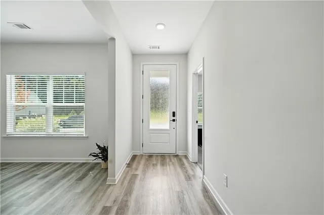 an empty room with wooden floor and windows