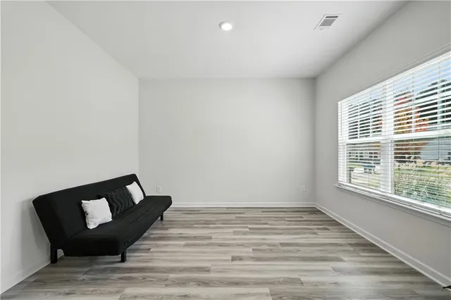 a view of a room with wooden floor and a window