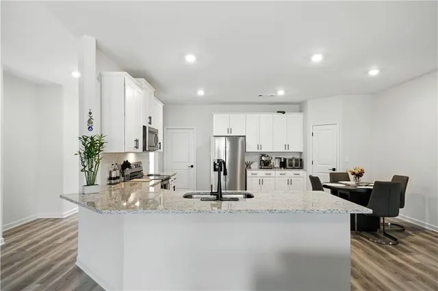 a view of kitchen with kitchen island stainless steel appliances sink refrigerator and microwave