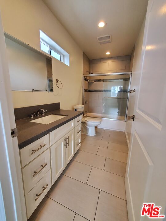 2227 Hauser Boulevard Los Angeles, CA 90016 - Photo 12 of 27 a bathroom with a granite countertop sink a toilet and a shower