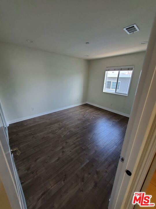 2227 Hauser Boulevard Los Angeles, CA 90016 - Photo 22 of 27 an empty room with wooden floor and windows