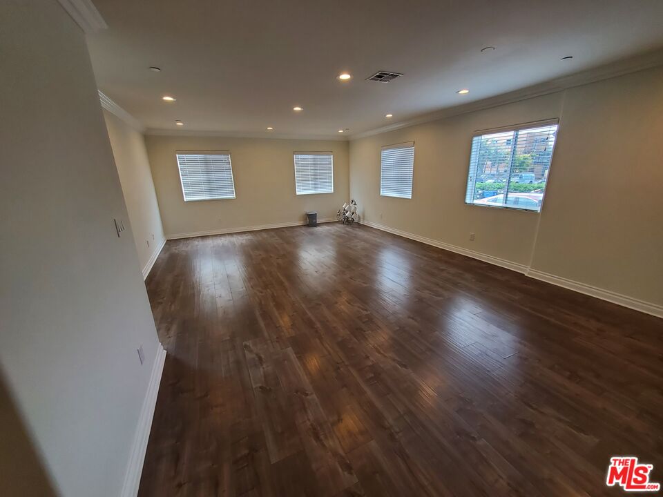 2227 Hauser Boulevard Los Angeles, CA 90016 - Photo 3 of 27 a view of an empty room with wooden floor and a window