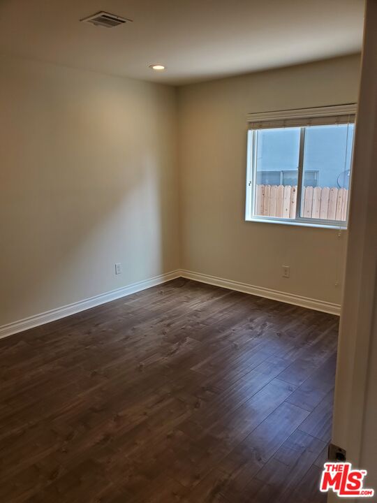 2227 Hauser Boulevard Los Angeles, CA 90016 - Photo 6 of 27 a view of an empty room with wooden floor and a window