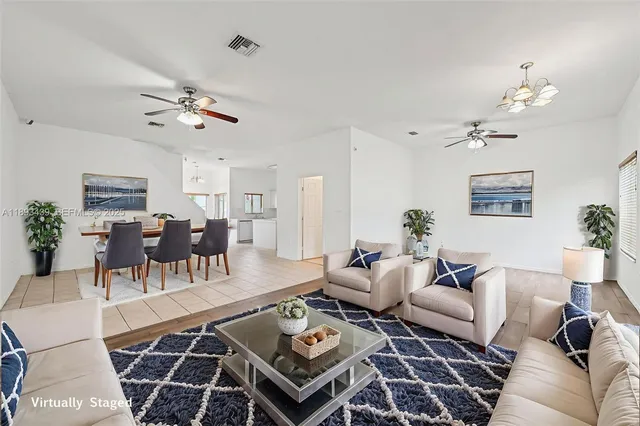 a living room with furniture a chandelier and a rug