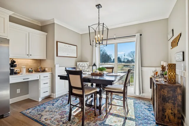 a kitchen with stainless steel appliances kitchen island granite countertop a stove a sink a refrigerator and white cabinets with wooden floor