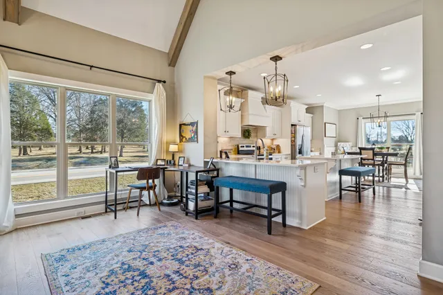 a kitchen with a sink a stove a refrigerator and white cabinets