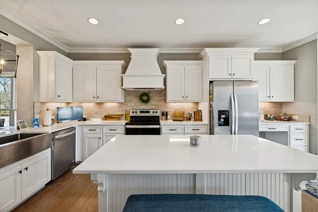 a spacious bedroom with a bed a couch and a flat tv screen on the dresser