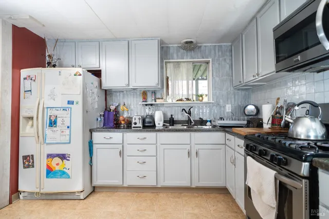 a kitchen with stainless steel appliances a stove a sink and a refrigerator