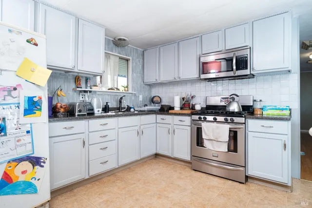 a kitchen with stainless steel appliances granite countertop a sink and a stove