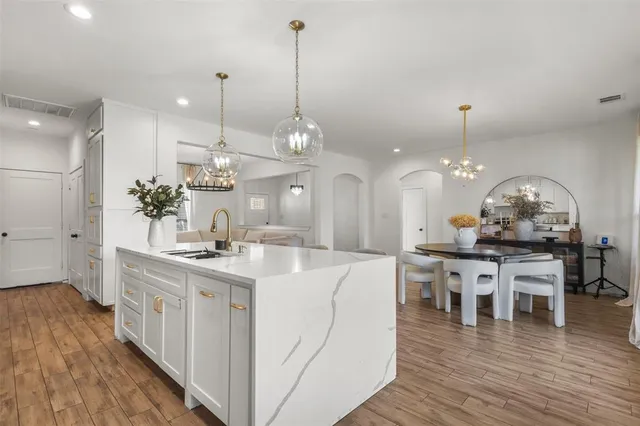 a view of a dining room and livingroom with furniture wooden floor a chandelier