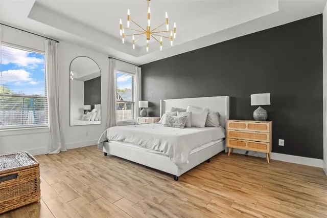 a bedroom with a large bed and a chandelier