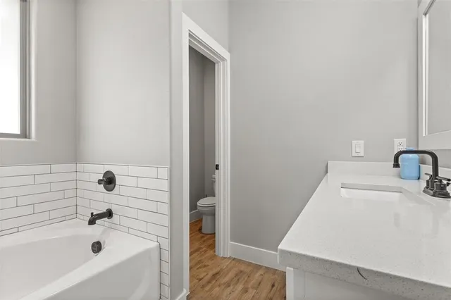 a bathroom with a tub sink and vanity