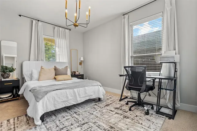 a bedroom with a bed a chair and a large window