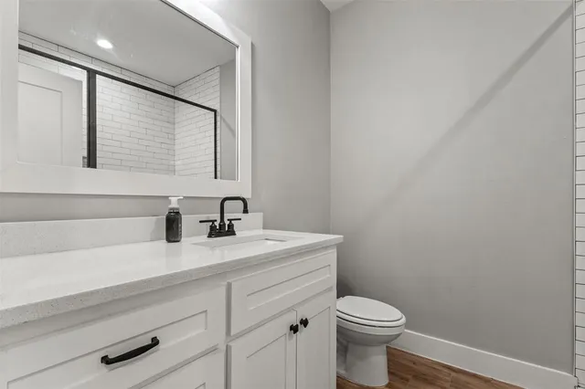 a bathroom with a toilet a sink a vanity and mirror