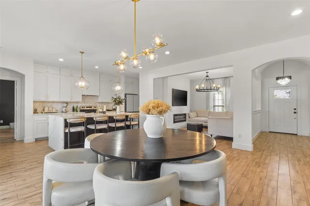 a kitchen with a dining table chairs and refrigerator