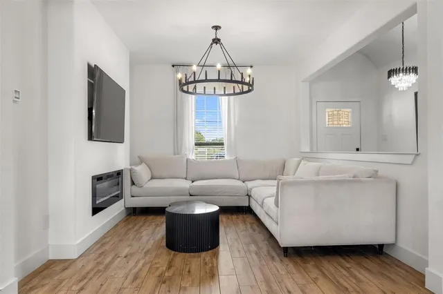 a living room with furniture a window and wooden floor