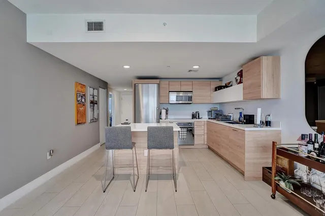 a kitchen with a table chairs microwave and cabinets