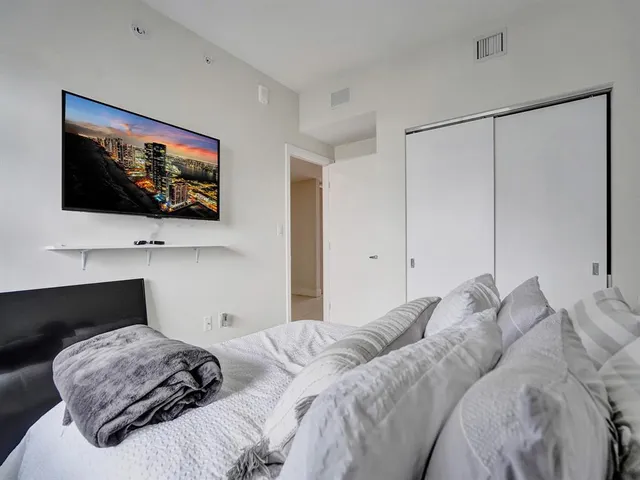 a bedroom with a bed and a flat screen tv