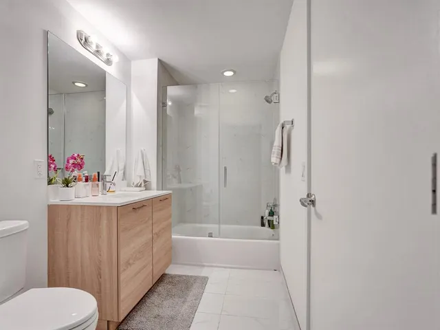 a bathroom with a tub sink mirror and toilet