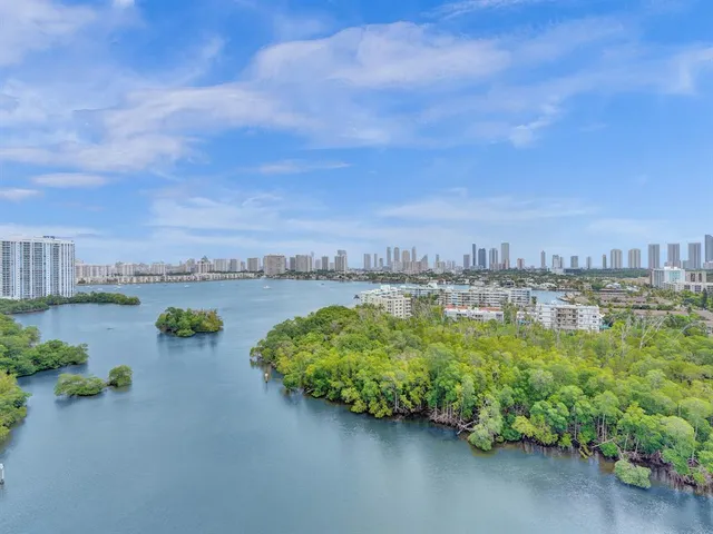 an aerial view of beach and lake with city view