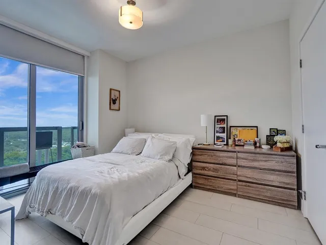 a bedroom with a bed and a large window