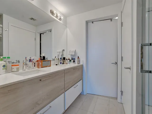 a bathroom with a double vanity sink mirror and bathtub