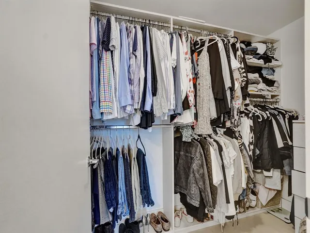 a view of walk in closet with clothes