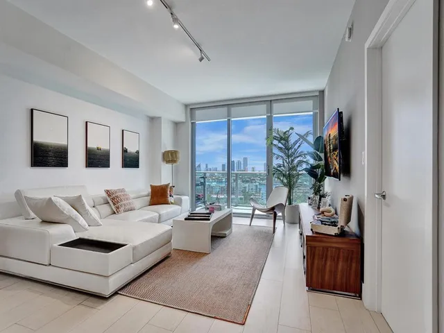 a living room with furniture large window and flat screen tv