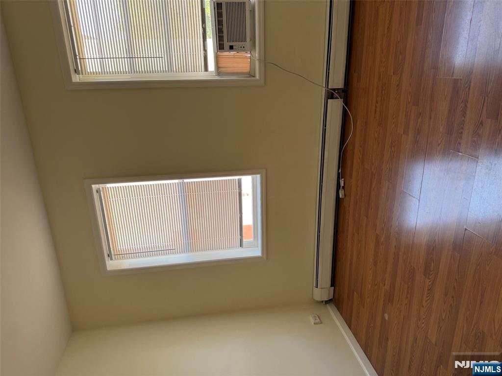 150 Park Avenue, Unit 1 East Rutherford, NJ 07073 - Photo 6 of 8 an empty room with wooden floor and windows