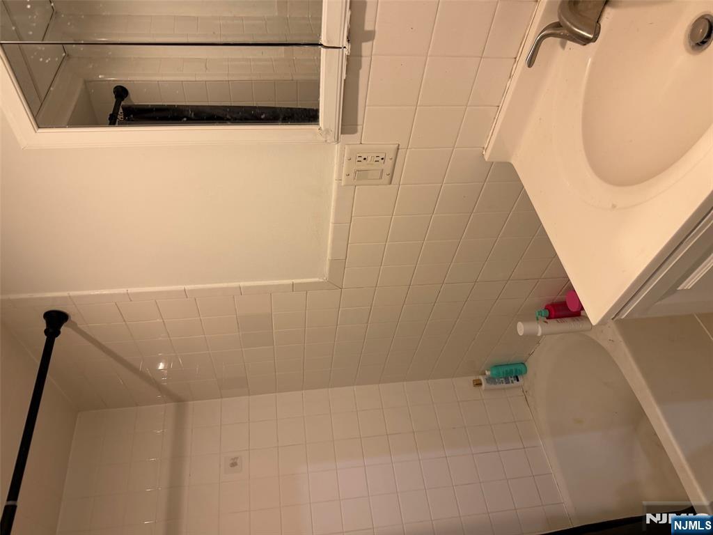 150 Park Avenue, Unit 1 East Rutherford, NJ 07073 - Photo 7 of 8 a bathroom with a white bath tub and a sink