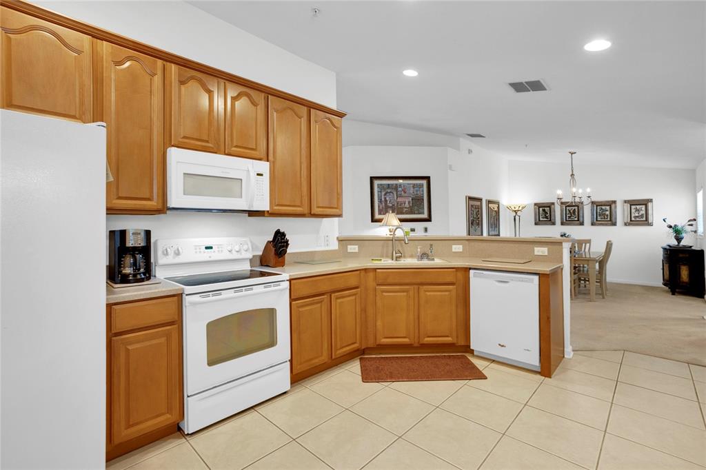 8310 Quimby Circle Davenport, FL 33896 - Photo 6 of 20 a kitchen with stainless steel appliances granite countertop a stove top oven a sink dishwasher and white cabinets with wooden floor
