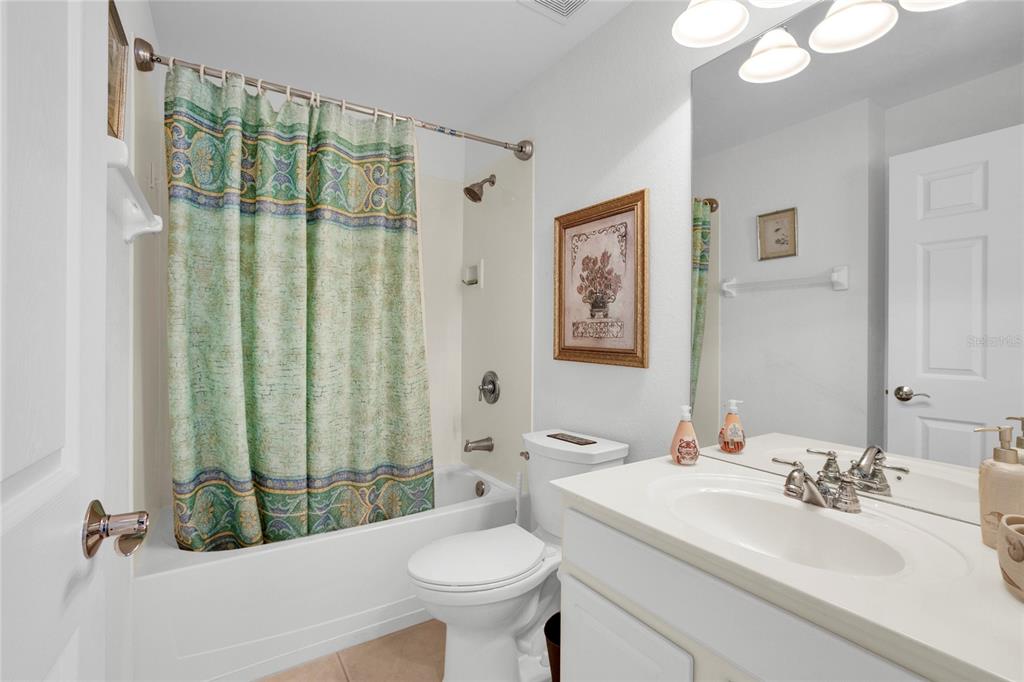 8310 Quimby Circle Davenport, FL 33896 - Photo 9 of 20 a bathroom with a sink and mirror with toilet