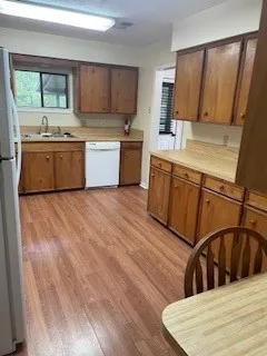 a kitchen with stainless steel appliances granite countertop a sink a stove a refrigerator cabinets and wooden floor