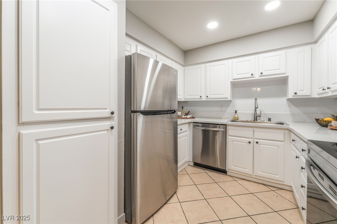 3151 North Soaring Gulls Drive, Unit 1083 Las Vegas, NV 89128 - Photo 11 of 45 Kitchen with stainless steel appliances, light countertops, white cabinets, light tile patterned flooring, and recessed lighting