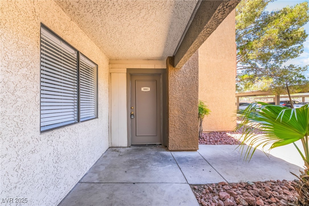 3151 North Soaring Gulls Drive, Unit 1083 Las Vegas, NV 89128 - Photo 31 of 45 Doorway to property with stucco siding and a patio area