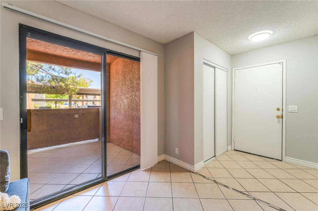 3151 North Soaring Gulls Drive, Unit 1083 Las Vegas, NV 89128 - Photo 4 of 45 Doorway with a textured ceiling and light tile patterned flooring