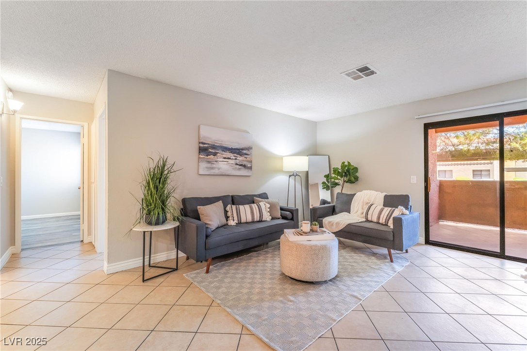 3151 North Soaring Gulls Drive, Unit 1083 Las Vegas, NV 89128 - Photo 6 of 45 Living room with a textured ceiling and light tile patterned floors