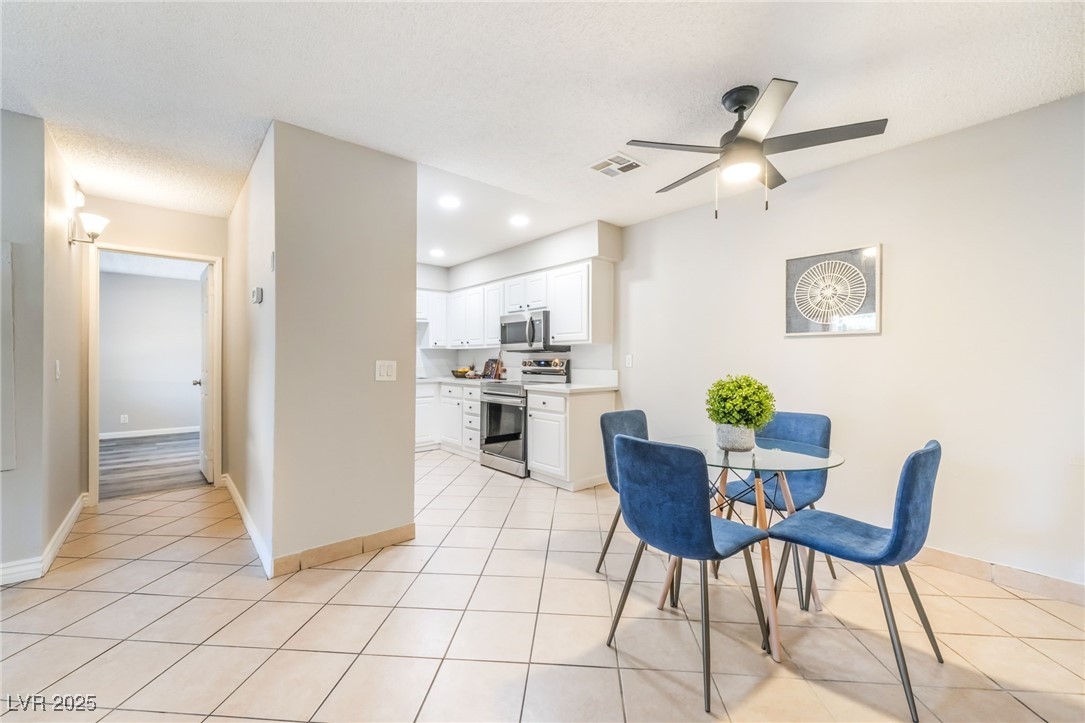3151 North Soaring Gulls Drive, Unit 1083 Las Vegas, NV 89128 - Photo 8 of 45 Dining space featuring a ceiling fan, light tile patterned flooring, recessed lighting, and a textured ceiling