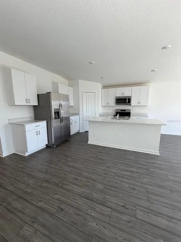 a large kitchen with cabinets and wooden floor