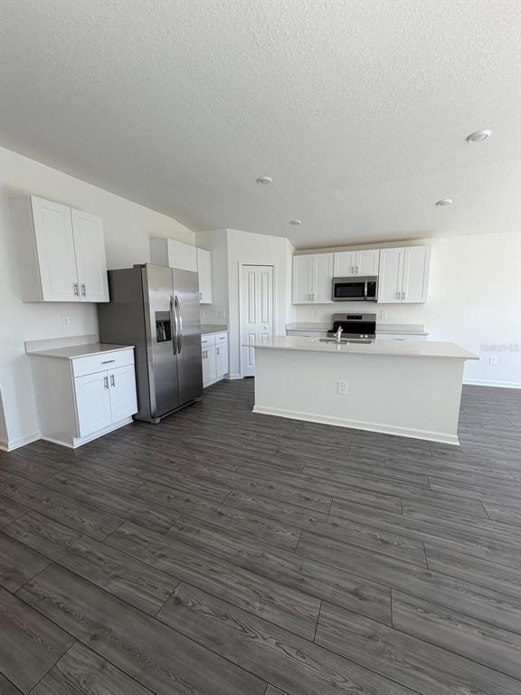 4741 Southwest 83rd Loop Ocala, FL 34476 - Photo 3 of 25 a large kitchen with cabinets and wooden floor