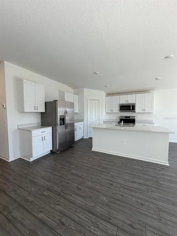a view of kitchen with wooden floor and electronic appliances