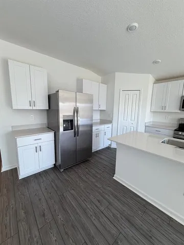 a kitchen with stainless steel appliances a refrigerator and wooden floor